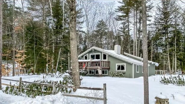 A two-story house with a balcony, surrounded by a snowy landscape and tall trees. - Bartlett Cabin 4 Min to Storyland / Fire Pit/ Dog friendly / Near Attitash (Bartlett)