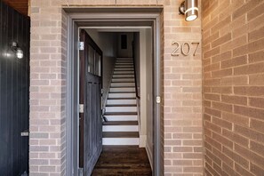 A narrow stairway leading to a door with the number 207 on the wall. - 12 South Townhome across from Sevier Park (Nashville)