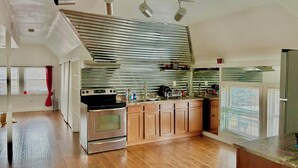 Une cuisine moderne avec des meubles en bois, des appareils en acier inoxydable et un grand îlot central.