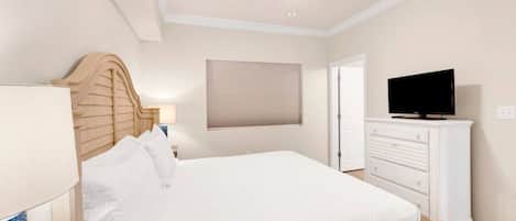 Ein Schlafzimmer mit einem Bett, einem Fernseher auf einer Kommode, einem Deckenventilator und einem Fenster mit Jalousien.