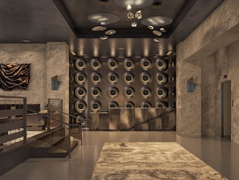 A bar area with a marble countertop, bar stools, a hanging light fixture, and a wine bottle on the counter. at Hotel Clark
