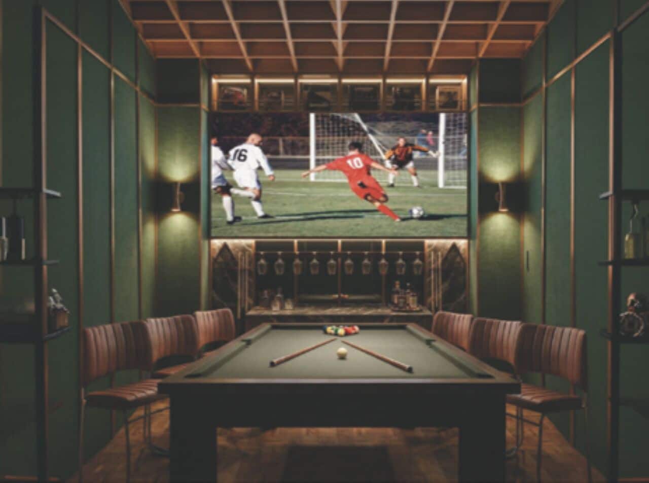 A billiards table with chairs, a pool table, and a television screen displaying a soccer game.