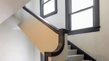 A modern staircase with a black and white color scheme, featuring a handrail and multiple steps.