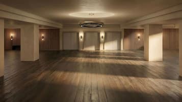 Un amplio vestíbulo de hotel con suelo de madera, una lámpara circular en el centro y listones de madera verticales en las paredes.