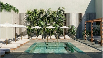 A modern interior with a staircase, a patterned wall, and a ceiling with circular light fixtures. at Hotel Clark