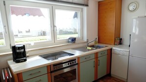 Une cuisine équipée d’une cuisinière, d’un four, d’un évier et d’une machine à café.