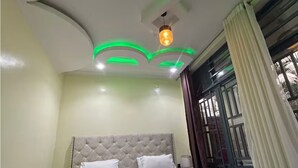 A bedroom with a tufted headboard, a bed with white bedding, and a patterned rug. - Novabeach Resort, with a scenic view of lake kivu 5 (Rubavu)