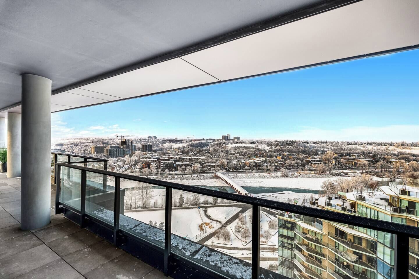 A high-rise building with a glass balcony overlooking a cityscape.