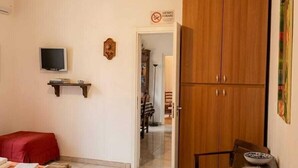 A bedroom with a bed, a TV, a wardrobe, and a desk with a chair. - Laura's little houses: second floor 1 (Palermo)