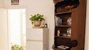 A kitchen with a white refrigerator, wooden cabinet, and potted plants. - Laura's little houses: second floor 1 (Palermo)