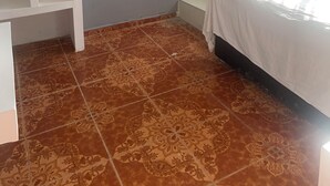 Une chambre avec un lit, une armoire blanche, une douche et une fenêtre.