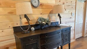 Un mur lambrissé en bois, orné d’une commode en bois foncé dotée de nombreux tiroirs et d’une coquille décorative.
