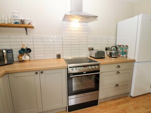 A kitchen with a stove, oven, microwave, toaster, and a kettle on the counter. - 1 Kyles Yard (Barnard Castle)