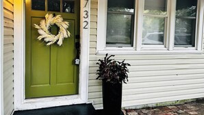 Una casa con una porta verde, un festone sulla porta e il numero 3732 sul muro.
