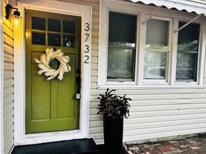 Ein Haus mit grüner Tür, einem Kranz an der Tür und der Hausnummer 3732 an der Wand.