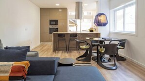 Una sala moderna con un sofá, una mesa de centro y un comedor con sillas y una mesa.