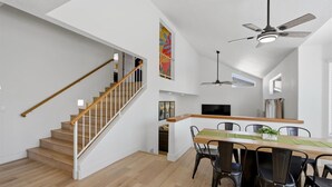 Et moderne interiør med trappe, spiseplads og en ventilator.