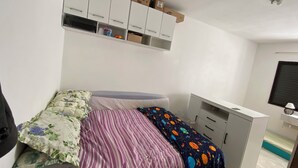 Une chambre à coucher comprenant un lit, un bureau et des placards de rangement.