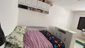 Une chambre à coucher avec un lit, un bureau et une armoire.