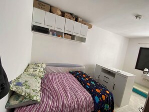 Ein Schlafzimmer mit einem Bett, einem Schreibtisch und einem Kleiderschrank.