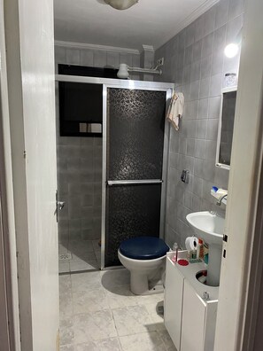 Ein Badezimmer mit Dusche, Toilette und Waschbecken.