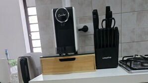 A kitchen with a gas stove, a coffee machine, and a knife set on the counter. There are two drawers below the counter. - Casa Manzoni (Novara)