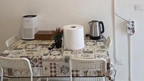 A dining area with a table set for two, a television mounted above, framed documents on the wall, and a no-smoking sign. - Casa Manzoni (Novara)