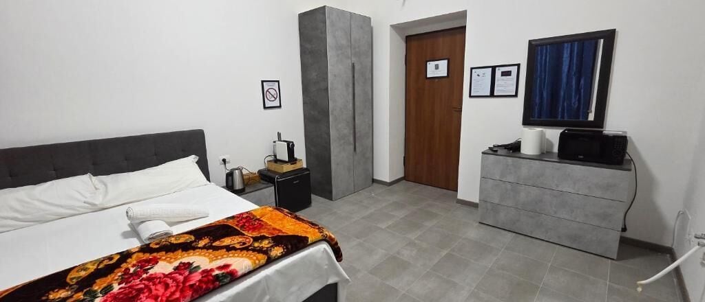 Ein Hotelzimmer mit Bett, Schreibtisch, Kleiderschrank und Fernseher.