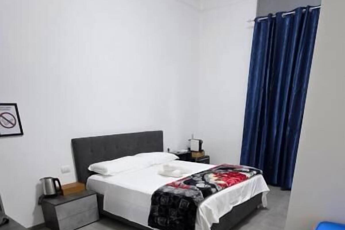 A modern bedroom with a bed, bedside table, and a nightstand.