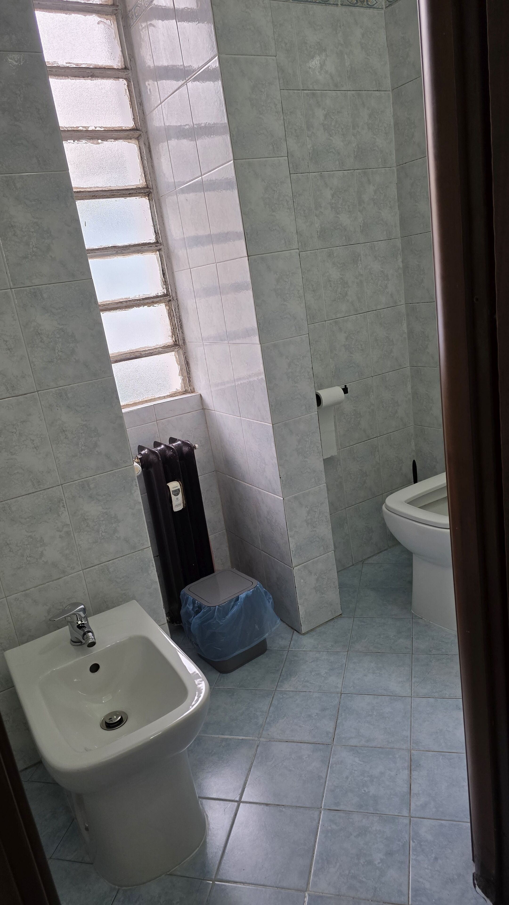 Un bagno con bidet, WC e una finestra.