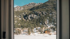 Un paysage de montagne avec un chalet et un sol recouvert de neige.