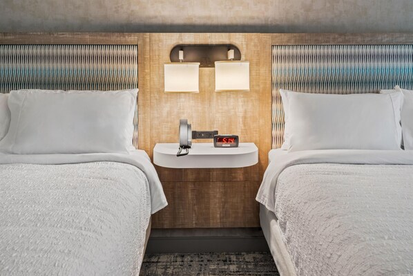 A hotel room with two beds, a bedside table with a clock, and a wall-mounted light fixture. - Hampton Inn By Hilton Aiken (Aiken)