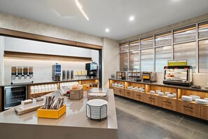 A modern breakfast area with a self-serve station, coffee machines, and a sandwich display. - Hampton Inn By Hilton Aiken (Aiken)