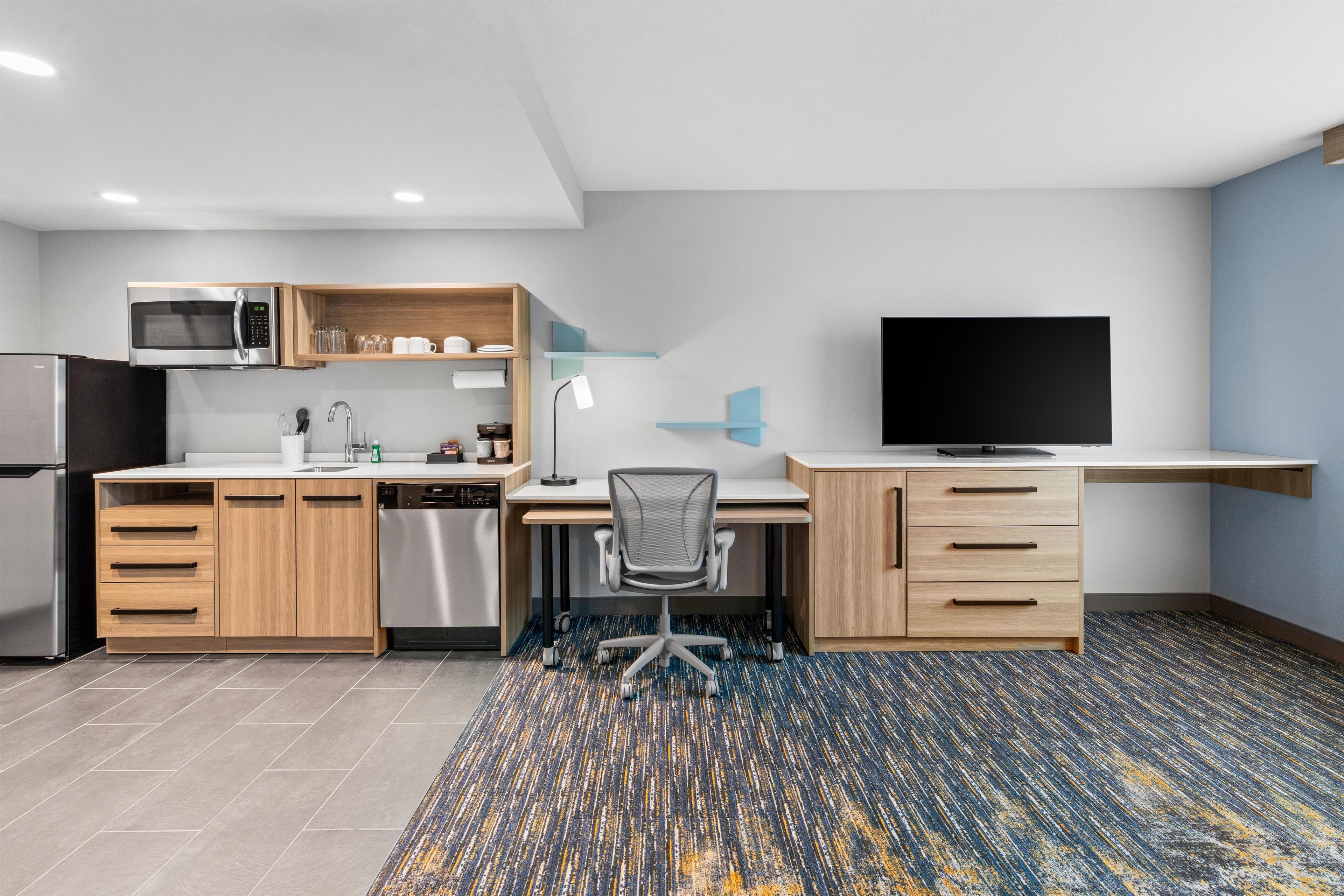 A modern kitchen with a microwave, refrigerator, and dishwasher.
