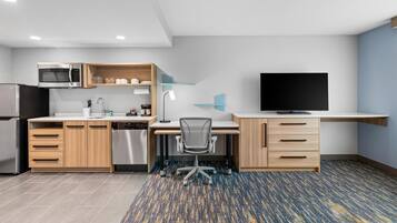 A modern kitchen with a microwave, refrigerator, and dishwasher.