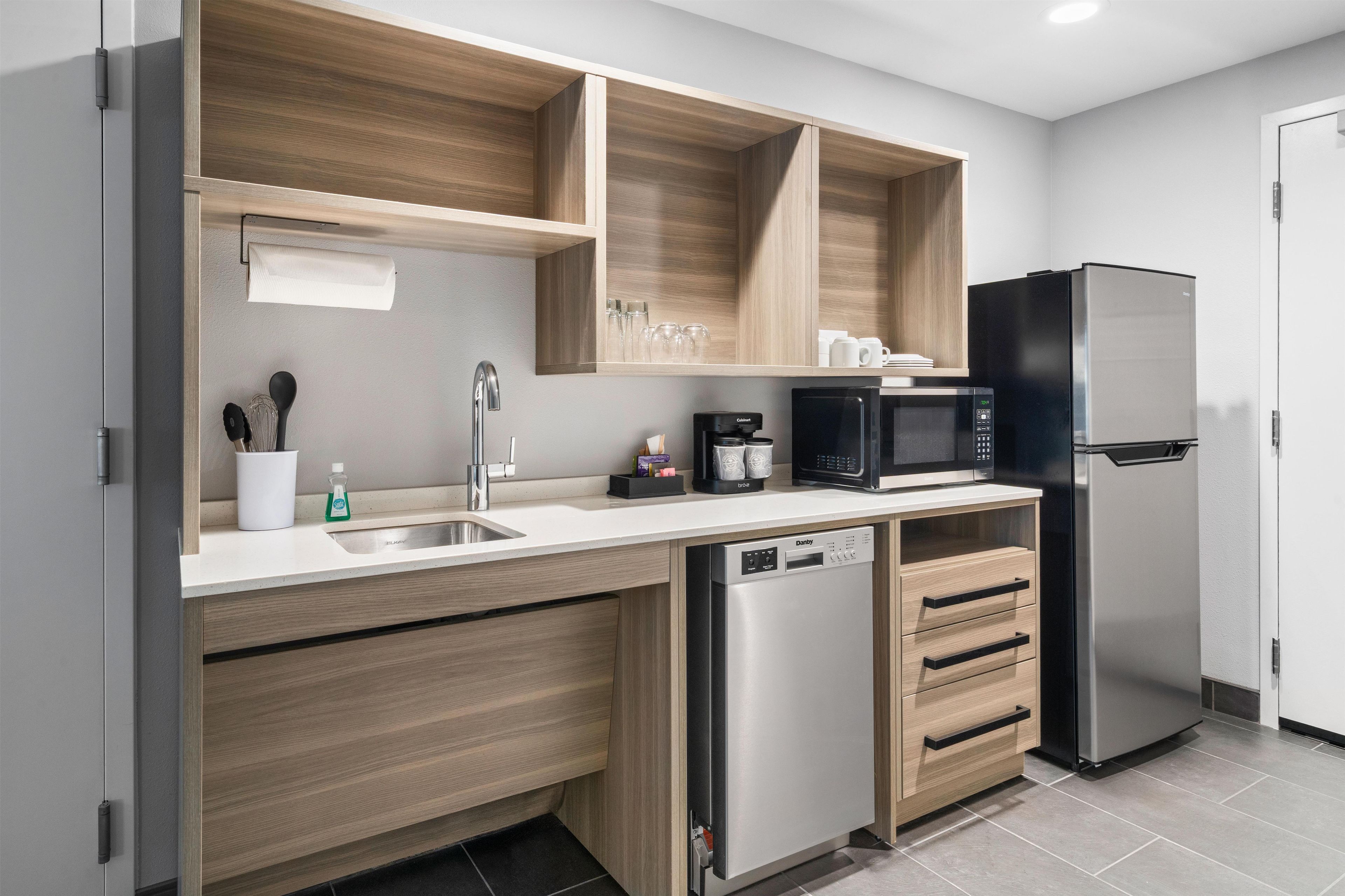 Una cocina moderna con lavavajillas incorporado, cafetera y refrigerador.