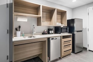 Una cocina moderna con lavavajillas incorporado, cafetera y refrigerador.