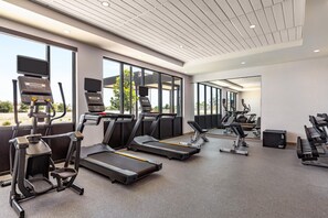 Una palestra moderna con tapis roulant, ellittiche e pesi liberi.