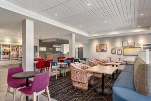 Un intérieur moderne avec des coins salon, un bar servant des collations et une cuisine en arrière-plan.