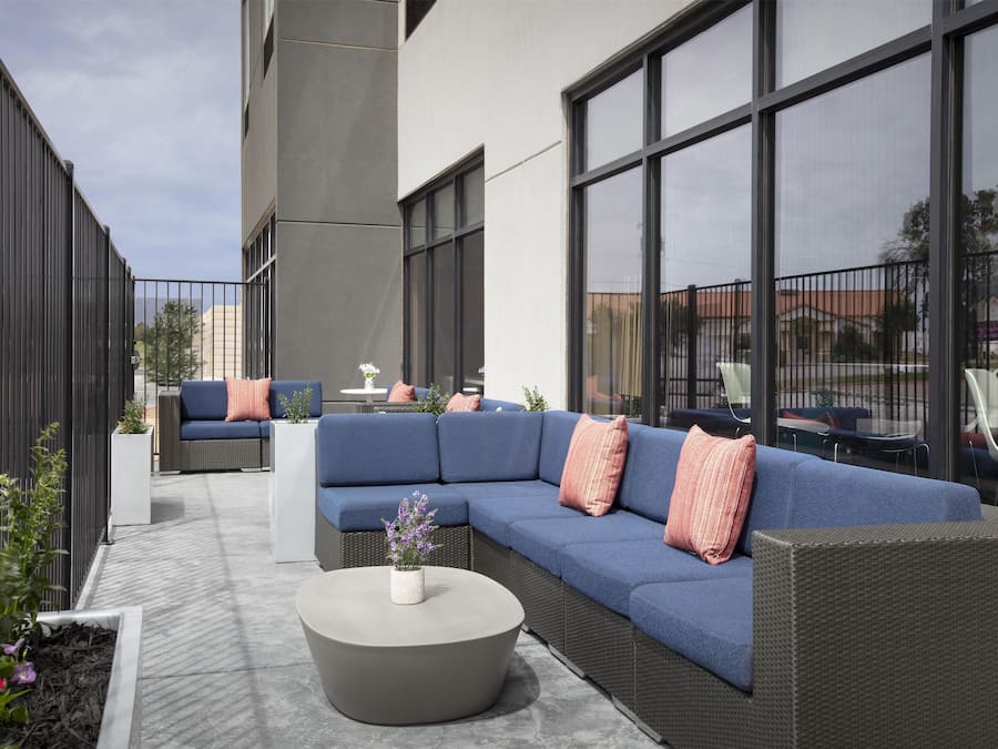 Un espace extérieur aménagé avec un canapé bleu, une table ronde et une plante en pot.