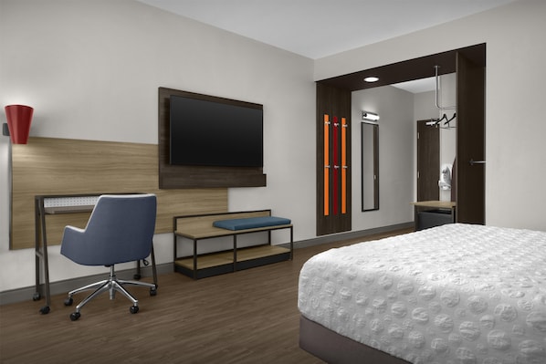 A modern hotel room with a bed, desk, chair, TV, and a shower area. - Tru By Hilton Midland East (Midland)