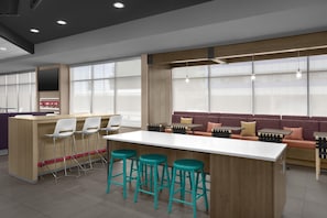 Un interior moderno con una zona de bar, asientos y ventanas amplias.