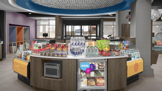 A self-service beverage station with a refrigerated display, a microwave, and a variety of snacks and drinks. - Tru By Hilton Midland East (Midland)