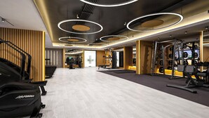 A modern gym with treadmills, weight machines, and a wooden wall design. - Hilton Garden Inn Bengaluru Embassy TechVillage Outer Ring Road (Bengaluru)