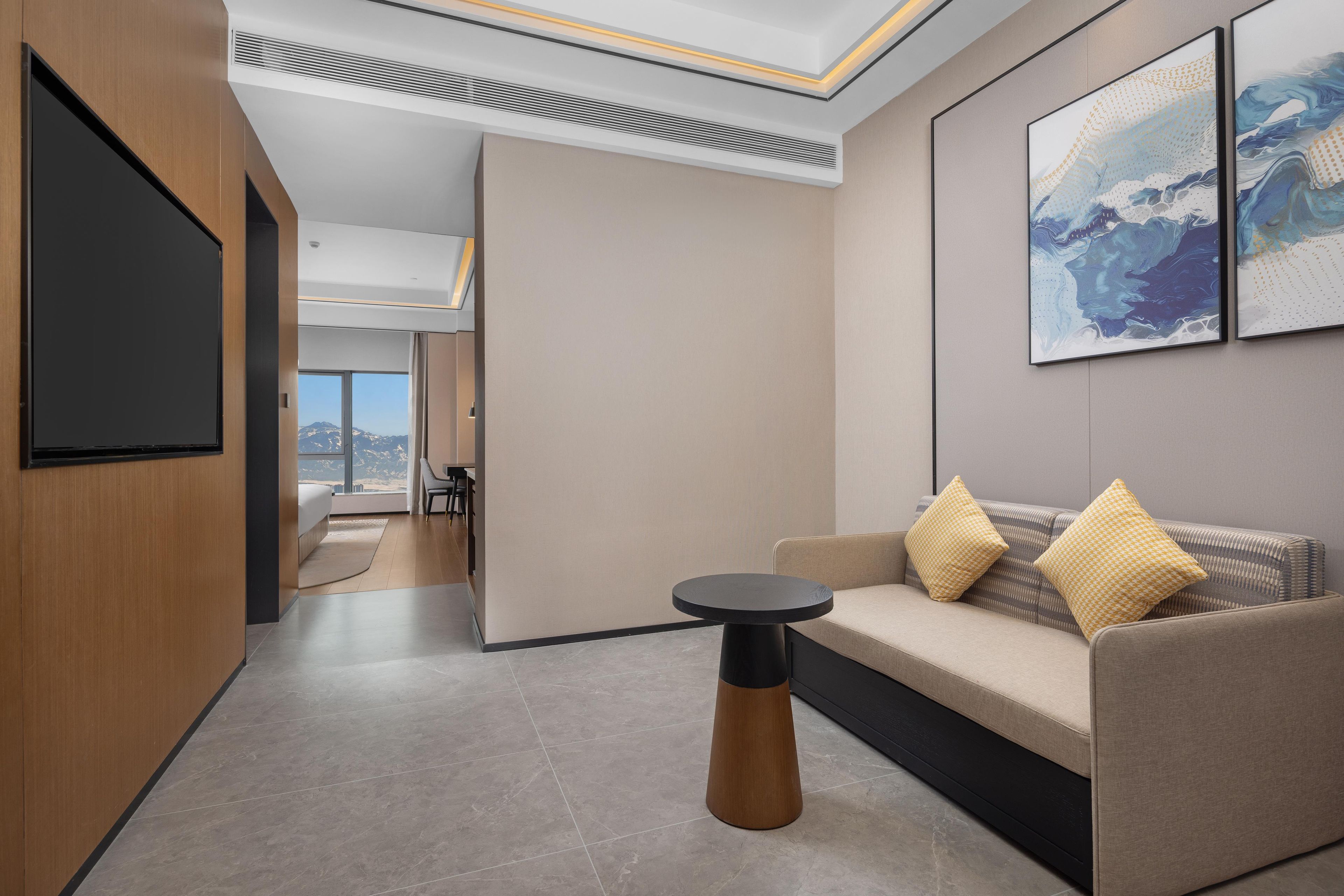 A modern living room with a sofa, a coffee table, and artwork on the wall.