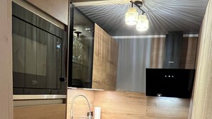 A modern kitchen with wooden cabinetry, a stainless steel sink, and a built-in oven.