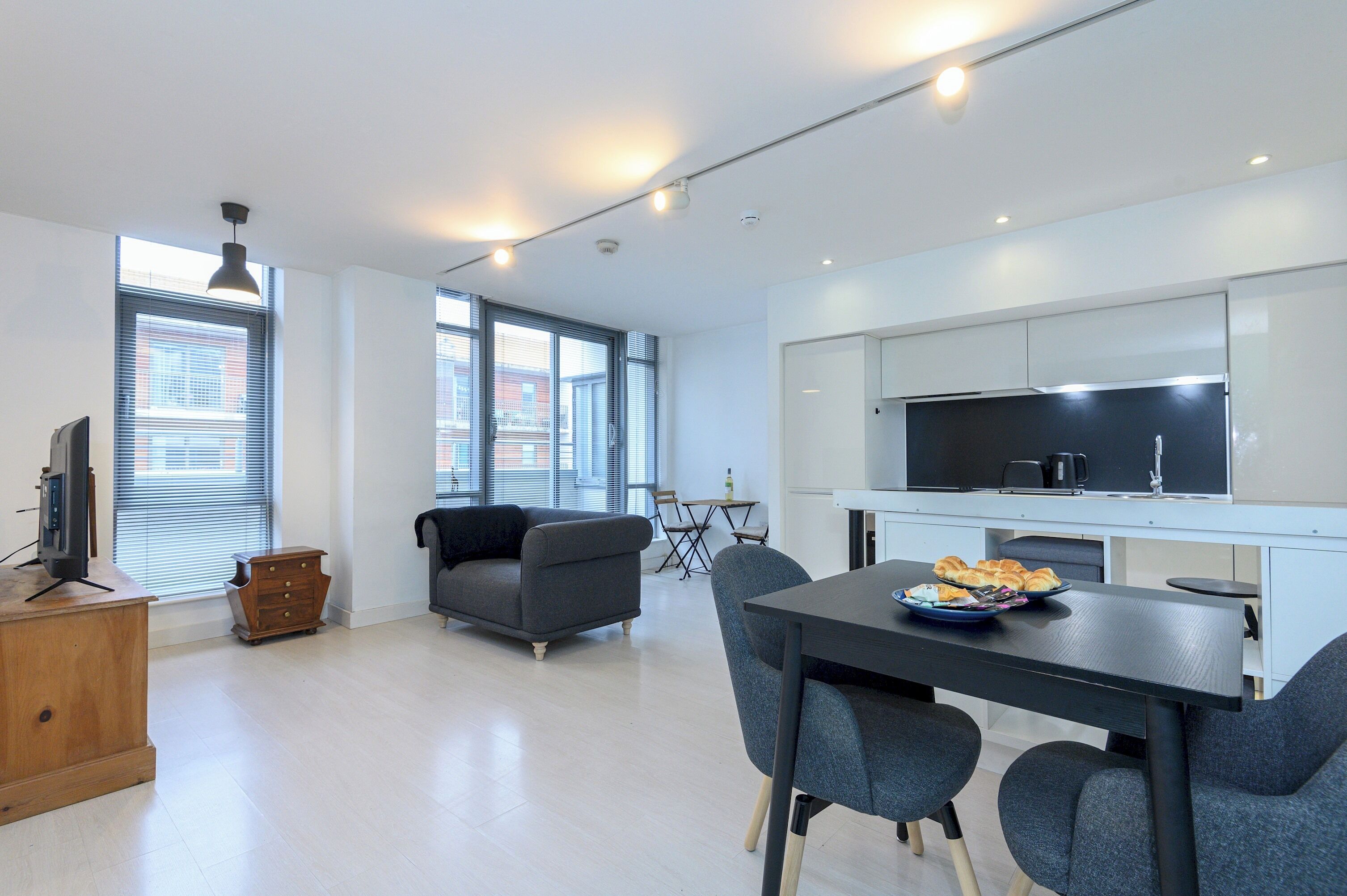 Un apartament modern amb zona de menjador, cuina i espai saló.