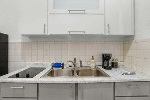 A kitchen with two sinks, a stove, and cabinets. - 2 Bedroom Apartment next to "La Placita" Santu1B (San Juan)