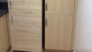 Eine Küche mit Holzschränken und einer schwarzen Arbeitsplatte.