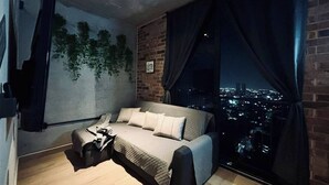 A bedroom with a city view, a bed, a small table, and a chair. - Travel VIP Lounge Themed. Private Parking (Monterrey)